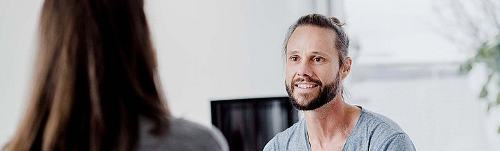 Ein Mann in einer Gesprächssituation mit einer Frau.